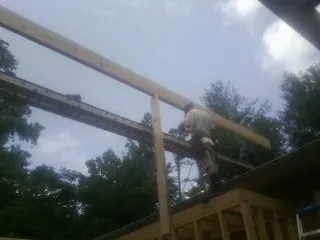 Carpenter setting a ridge beam over a new addition frame — Ice Dam Removal by Roofing Brothers in Clifton Heights