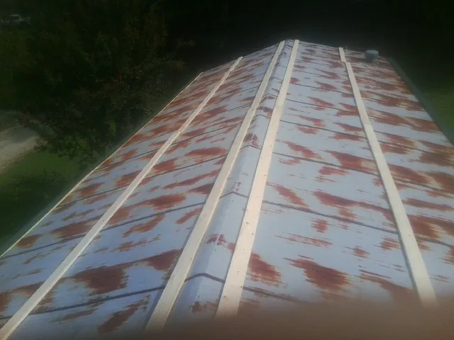 Rusted metal roof panels with new wood purlins before replacement — Storm Damage Roof Repair in Clifton Heights by Roofing Brothers